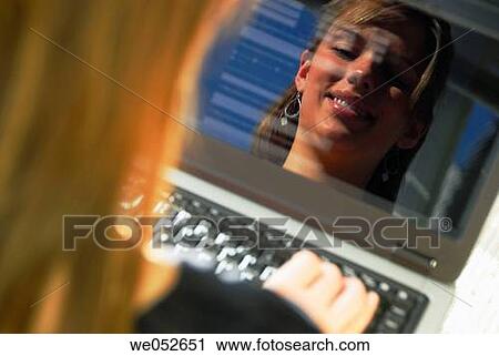 reflection of 20 yr old woman typing on laptop computer smiling View Large Photo Image Stock Image - reflection of 20 yr old woman typing on laptop computer smiling. Fotosearch
