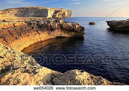 Sunset at the cliffs of Dwerja, on the island of Gozo, Malta View Large Photo Image Stock Photograph - Sunset at the cliffs of Dwerja, on the island of Gozo, Malta. Fotosearch