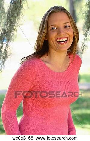 Stock Photo - Young blonde woman in the park. Laughing on camera.. Fotosearch