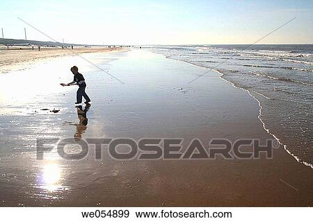 Stock Photo - Young boy with shovel playing on the beach, Beverwijk, Holland, Netherlands. Fotosearch
