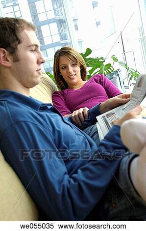 young couple at home looking at newspaper together View Large Photo Image Stock Photography - young couple at home looking at newspaper together. Fotosearch