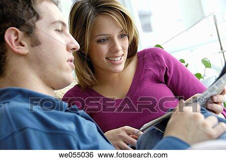 young couple reading newspaper together at home View Large Photo Image Stock Photograph - young couple reading newspaper together at home. Fotosearch