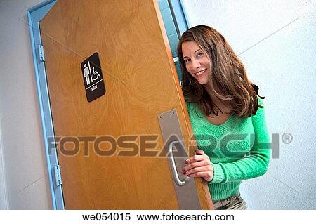 Young woman standing in the doorway of a men's bathroom View Large Photo Image Stock Photography - Young woman standing in the doorway of a men's bathroom. Fotosearch