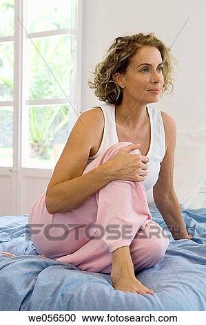Stock Image - at-home, barefoot, baby boomer, absorbed. Fotosearch