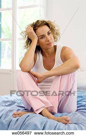 Stock Photo - at-home, barefoot, baby boomer, absorbed. Fotosearch