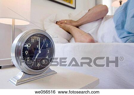 Stock Photograph - at-home, bedroom, bed, baby boomer, alarm-clock. Fotosearch