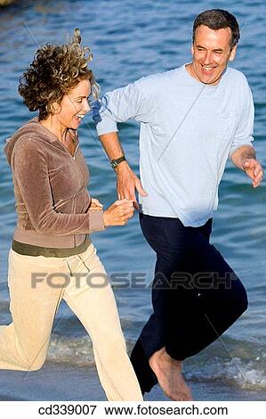 Stock Photo - baby boomer, beach, barefoot, activity. Fotosearch