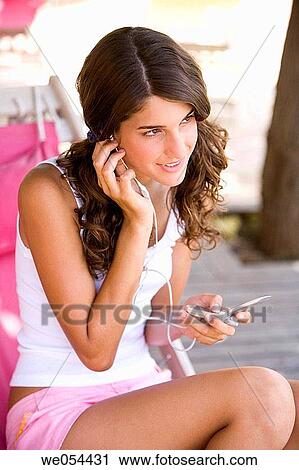 Stock Image - brunette, cell phone, adolescence. Fotosearch