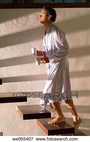 man in bathrobe stepping up stairs and holding mugs View Large Photo Image Stock Photo - man in bathrobe stepping up stairs and holding mugs. Fotosearch