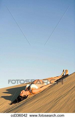 Stock Image - Pregnant Woman Lying on a Dune. Fotosearch
