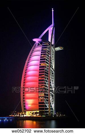 Stock Image - The 7 star luxury Burj al Arab Hotel by night, seen from the grounds of the 5 Star luxury Jumeirah Beach Resort Hotel at Jumeirah Beach, Dubai, United Arab Emirates. Fotosearch
