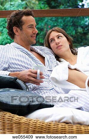 young couple in bathrobe relaxing on sofa View Large Photo Image Stock Photo - young couple in bathrobe relaxing on sofa. Fotosearch