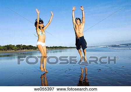 young couple jumping on the beach View Large Photo Image Stock Photo - young couple jumping on the beach. Fotosearch