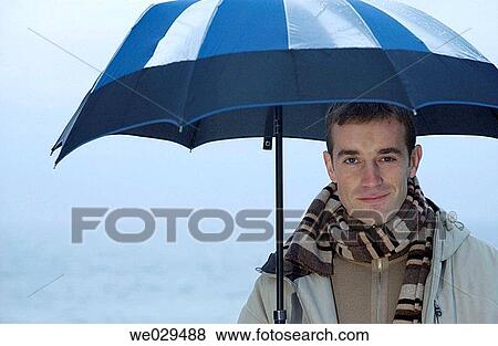 Young man under an umbrella. San Sebastißn-Donostia. Guip·zcoa. Euskadi. Spain View Large Photo Image Stock Photo - Young man under an umbrella. San Sebastißn-Donostia. Guip·zcoa. Euskadi. Spain. Fotosearch