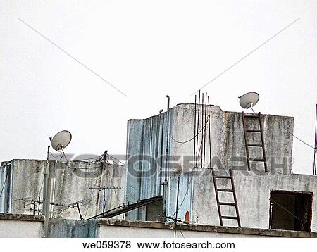A dish antennas of a television set on a building terrace. Pune, Maharashtra, India. View Large Photo Image Stock Photo - A dish antennas of a television set on a building terrace. Pune, Maharashtra, India.. Fotosearch
