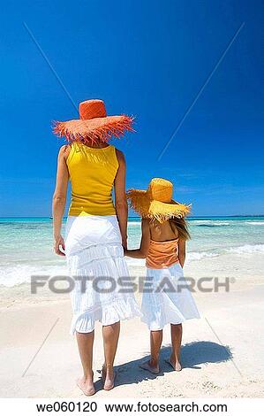 Stock Image - back view, calm, beach, barefoot, accessory. Fotosearch