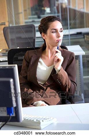 Stock Image - Ball-point pen, business, brunette, absorbed. Fotosearch