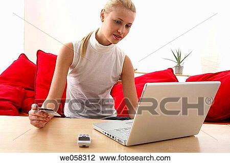 Stock Image - Bank card, cell phone, blond, at-home. Fotosearch