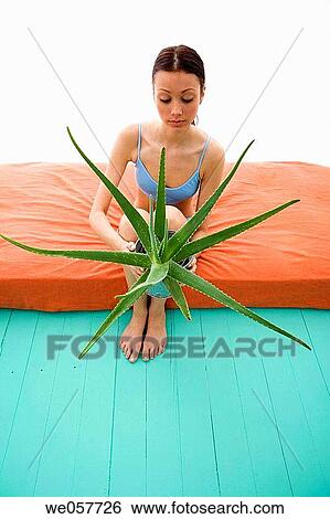 Stock Photograph - barefoot, brunette, Body care, aloe vera. Fotosearch