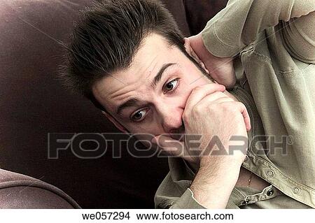 Picture - Close_up of a young man resting on a sofa. Fotosearch