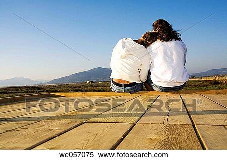 Stock Photography - Couple Relaxing On Wood Deck. Fotosearch