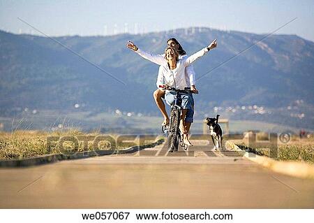 Couple Ridding a Bike With Their Dog View Large Photo Image Stock Photo - Couple Ridding a Bike With Their Dog. Fotosearch