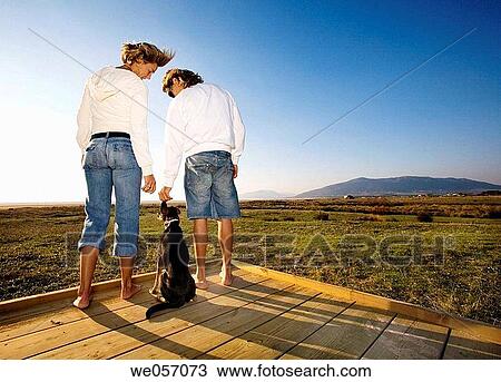 Stock Image - Couple With Their Dog Enjoying Scenery. Fotosearch
