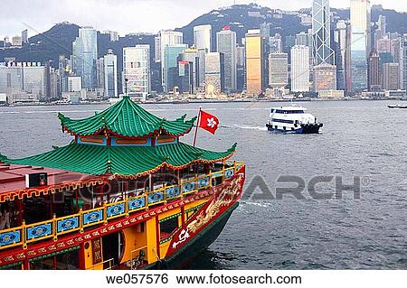 Junk, restored as restaurant boat, in the bay in front of Hong Kong Island with Hong Kong's skyline in the early evening hours, Hong Kong, China, Asia View Large Photo Image Stock Photograph - Junk, restored as restaurant boat, in the bay in front of Hong Kong Island with Hong Kong's skyline in the early evening hours, Hong Kong, China, Asia. Fotosearch