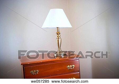 Stock Photography - Lamp setting on top of a bureau in a bedroom. Fotosearch
