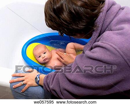 Mother giving three_month_old baby a bath View Large Photo Image Stock Photography - Mother giving three_month_old baby a bath. Fotosearch