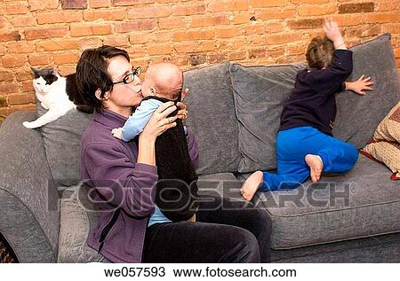 Mother with three_year_old and three_month_old on the couch with cat looking on. View Large Photo Image Stock Image - Mother with three_year_old and three_month_old on the couch with cat looking on.. Fotosearch