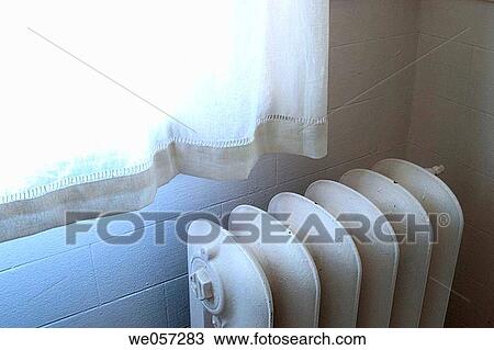 Stock Image - Old iron radiator next to a window. Fotosearch