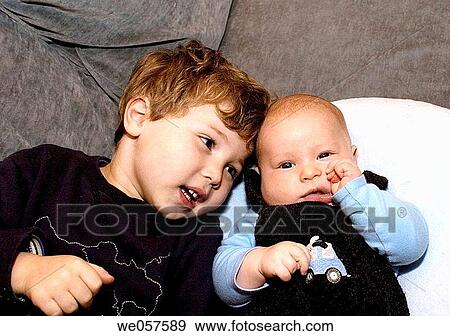 Three_month_old and three_year_old on a couch View Large Photo Image Stock Photo - Three_month_old and three_year_old on a couch. Fotosearch