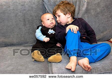 Three_month_old and three_year_old sitting on a couch View Large Photo Image Stock Image - Three_month_old and three_year_old sitting on a couch. Fotosearch