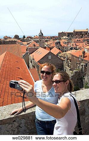 Two women taking their photo. Dubrovnik, Croatia View Large Photo Image Stock Image - Two women taking their photo. Dubrovnik, Croatia. Fotosearch