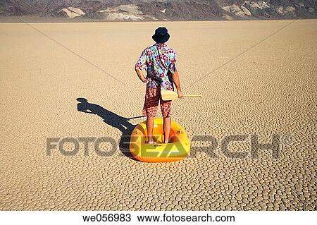 Usa. California. Death Valley National Park. Racetrack point. Man with inflatable boat View Large Photo Image Stock Image - Usa. California. Death Valley National Park. Racetrack point. Man with inflatable boat. Fotosearch