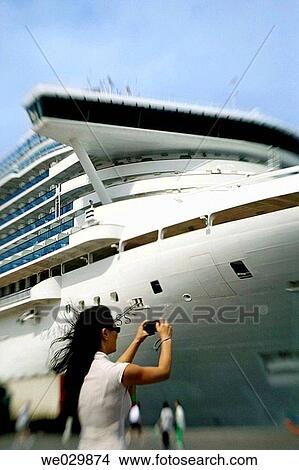 Woman taking a photo of a cruiseship View Large Photo Image Picture - Woman taking a photo of a cruiseship. Fotosearch