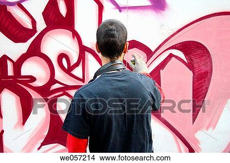 Young man painting a graffiti View Large Photo Image Picture - Young man painting a graffiti. Fotosearch