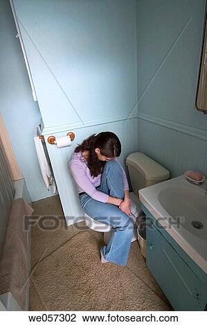 Young woman sitting in her bathroom View Large Photo Image Stock Image - Young woman sitting in her bathroom. Fotosearch