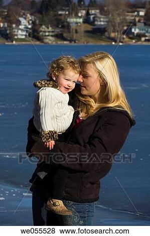 A woman holds her daughter at the beach. View Large Photo Image Stock Photo - A woman holds her daughter at the beach.. Fotosearch