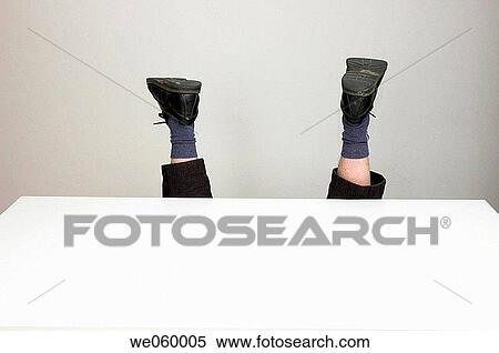 Stock Photography - Anonymous office worker fallen over behind an empty desk.. Fotosearch