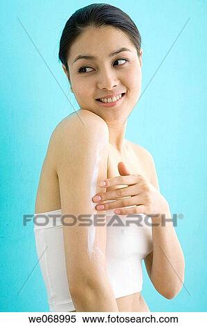 Stock Photography - arm, Body care, Asian, apply. Fotosearch