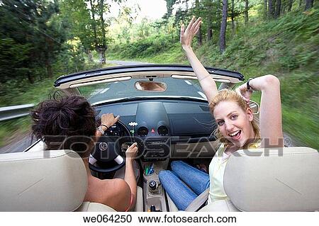 Stock Image - Arms raised, carefree, car, automobile, amusement. Fotosearch