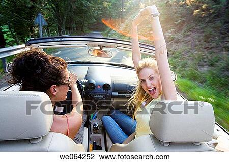 Stock Image - Arms raised, carefree, car, automobile, amusement. Fotosearch