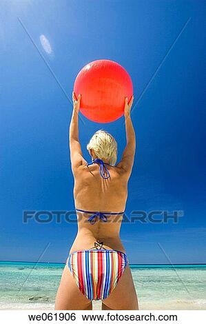 Stock Photograph - back view, beach, ball, Arms raised. Fotosearch