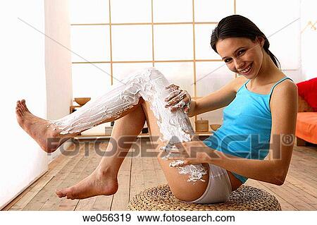 Stock Photo - barefoot, brunette, Body care, apply. Fotosearch