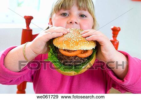Stock Photo - big, bite, biting, blond, burger, calorie. Fotosearch