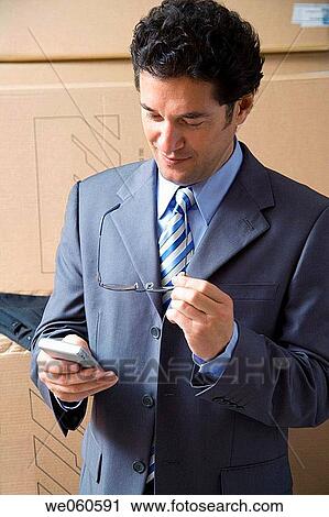 Stock Image - black hair, businessman, businesspeople, cell phone. Fotosearch