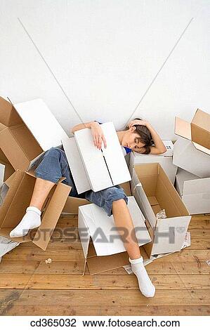 Stock Image - brunette, cardboard, at-home. Fotosearch