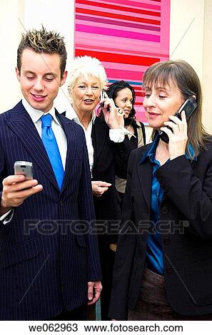 Stock Image - Business team using mobile phones.. Fotosearch